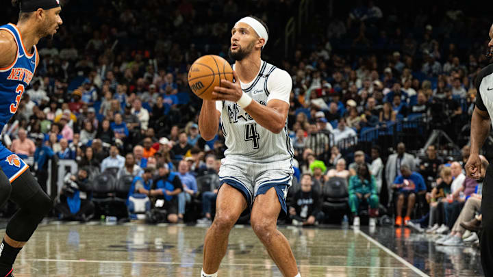 Dec 15, 2024; Orlando, Florida, USA; Orlando Magic guard Jalen Suggs (4) shoots the ball against New York Knicks forward Josh Hart (3) in the fourth quarter at Kia Center. Mandatory Credit: Jeremy Reper-Imagn Images