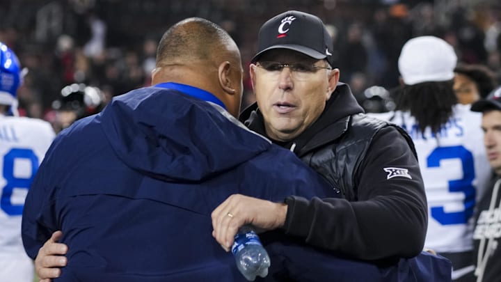 Nov 22, 2025; Cincinnati, Ohio, USA; Cincinnati Bearcats head coach Scott Satterfield, right, hugs BYU Cougars head coach Kalani Sitake after their game at Nippert Stadium. Mandatory Credit: Aaron Doster-Imagn Images Nov 22, 2025; Cincinnati, Ohio, USA; Cincinnati Bearcats head coach Scott Satterfield, right, hugs BYU Cougars head coach Kalani Sitake after their game at Nippert Stadium. Mandatory Credit: Aaron Doster-Imagn Images