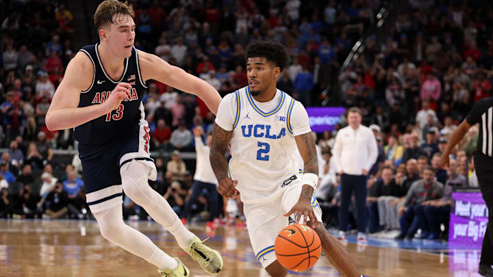 Nov 14, 2025; Inglewood, California, USA;  UCLA Bruins guard Donovan Dent (2) drives to the basket against Arizona Wildcats center Motiejus Krivas (13) during the second half of the Hall of Fame Series game at Intuit Dome. Mandatory Credit: Kiyoshi Mio-Imagn Images