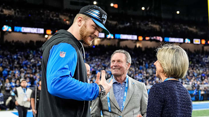 Detroit Lions defensive end Aidan Hutchinson (97) talks to principal owner and chair Sheila Ford Hamp, right, and her husband Steve Hamp before the game between Detroit Lions and Minnesota Vikings at Ford Field in Detroit on Sunday, Jan. 5, 2025.