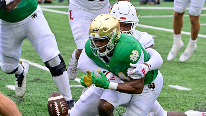 Sep 28, 2024; South Bend, Indiana, USA; Notre Dame Fighting Irish running back Jadarian Price (24) fumbles against the Louisville Cardinals in the second quarter at Notre Dame Stadium. Mandatory Credit: Matt Cashore-Imagn Images