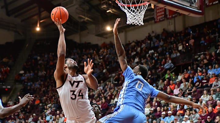 Mar 4, 2025; Blacksburg, Virginia, USA; Virginia Tech Hokies forward Mylyjael Poteat (34) goes up for a shot as North Carolina Tar Heels forward Ty Claude (0) defends during the first half at Cassell Coliseum. Mandatory Credit: Brian Bishop-Imagn Images