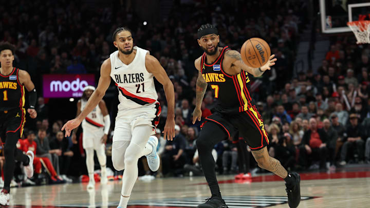 Jan 15, 2026; Portland, Oregon, USA;  Portland Trail Blazers guard/forward Rayan Rupert (21) and Atlanta Hawks guard Nickel Alexander-Walker (7) battle for a loose ball during the second half at Moda Center. Mandatory Credit: Jaime Valdez-Imagn Images