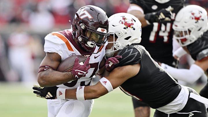 Nov 4, 2023; Louisville, Kentucky, USA;  Virginia Tech Hokies running back Bhayshul Tuten (33) runs the ball against Louisville Cardinals defensive back Cam'Ron Kelly during the first half at L&N Federal Credit Union Stadium. Mandatory Credit: Jamie Rhodes-Imagn Images