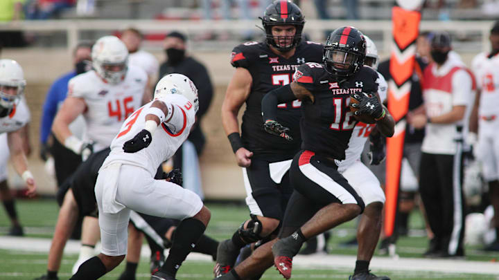 Sep 12, 2020; Lubbock, Texas, USA;  Texas Tech Red Raiders running back Ja Lynn Polk (12) looks for running room against Houston Baptist Huskies safety Isaiah Cash (3) in the first half at Jones AT&T Stadium. Mandatory Credit: Michael C. Johnson-Imagn Images
