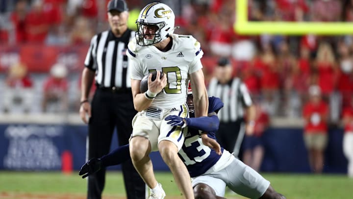Sep 16, 2023; Oxford, Mississippi, USA; Georgia Tech Yellow Jackets quarterback Haynes King (10) spins to avoid a tackle attempt by Mississippi Rebels defensive back Ladarius Tennison (13) during the second half at Vaught-Hemingway Stadium. Mandatory Credit: Petre Thomas-Imagn Images