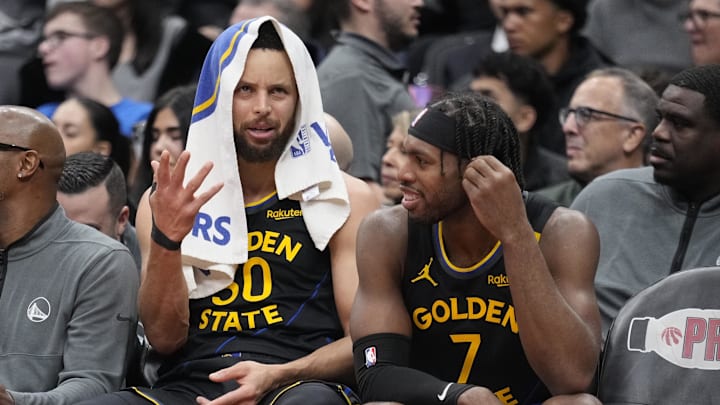 Jan 13, 2025; Toronto, Ontario, CAN; Golden State Warriors guard Stephen Curry (30) and guard Buddy Hield (7) talk on the bench during the second half against the Toronto Raptors at Scotiabank Arena. Mandatory Credit: John E. Sokolowski-Imagn Images