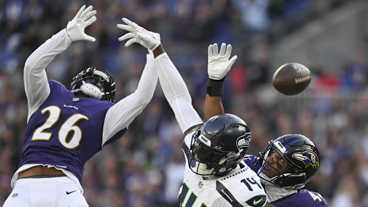 Baltimore Ravens defensive backs Geno Stone and Marlon Humphrey break up a pass against Seattle Seahawks receiver DK Metcalf