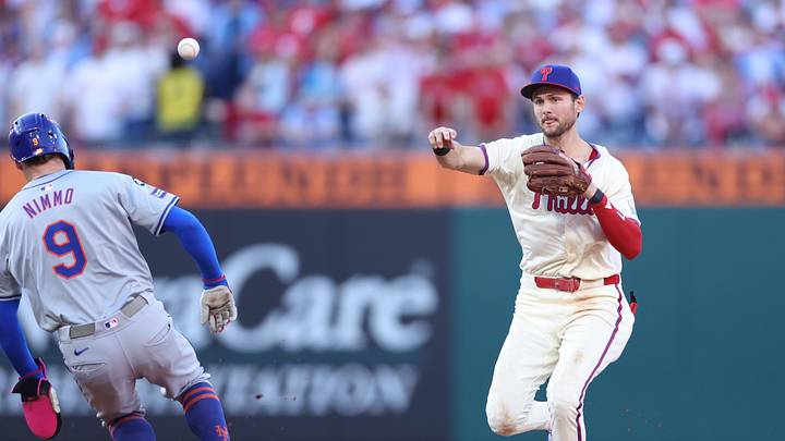 Oct 5, 2024; Philadelphia, PA, USA; Philadelphia Phillies shortstop Trea Turner (7) turns a double play against New York Mets outfielder Brandon Nimmo (9) in the fourth inning in game one of the NLDS for the 2024 MLB Playoffs at Citizens Bank Park. Mandatory Credit: Bill Streicher-Imagn Images