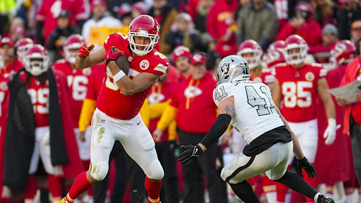 Nov 29, 2024; Kansas City, Missouri, USA; Kansas City Chiefs tight end Travis Kelce (87) runs with the ball against Las Vegas Raiders linebacker Robert Spillane (41) during the first half at GEHA Field at Arrowhead Stadium. Mandatory Credit: Jay Biggerstaff-Imagn Images