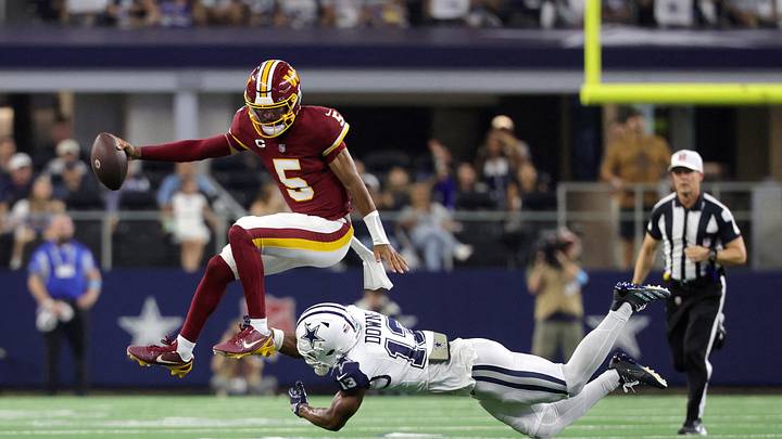 Sep 20, 2026; Arlington, Texas, USA; Washington Commanders quarterback Jayden Daniels (5) leaps to avoid a tackle by Dallas Cowboys safety Caleb Downs (13) Sep 20, 2026; Arlington, Texas, USA; Washington Commanders quarterback Jayden Daniels (5) leaps to avoid a tackle by Dallas Cowboys safety Caleb Downs (13)