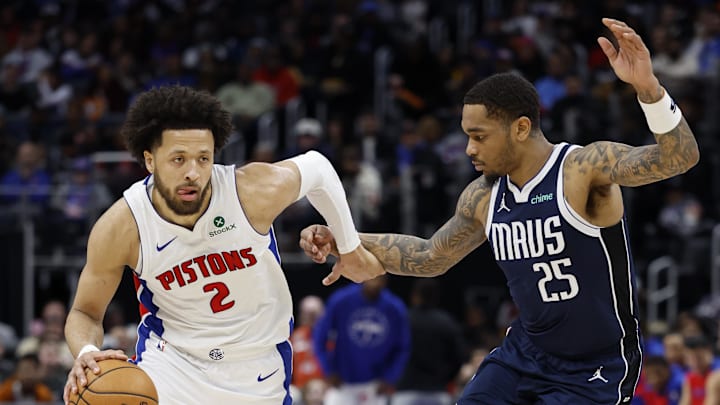 Jan 31, 2025; Detroit, Michigan, USA;  Detroit Pistons guard Cade Cunningham (2) dribbles defended by Dallas Mavericks forward P.J. Washington (25) in the second half at Little Caesars Arena. Mandatory Credit: Rick Osentoski-Imagn Images