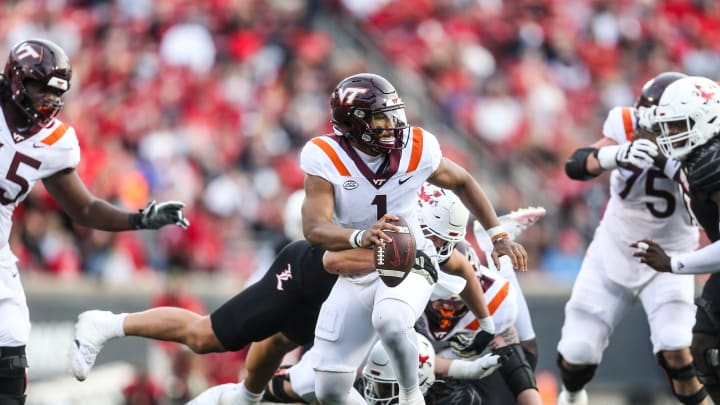 Louisville Cardinals defensive lineman Mason Reiger (95) gets an arm around Virginia Tech Hokies quarterback Kyron Drones (1) as the Cards rolled past Virginia Tech 34-3 Saturday. Nov.4, 2023.