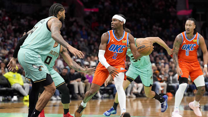Dec 28, 2024; Charlotte, North Carolina, USA; Oklahoma City Thunder guard Shai Gilgeous-Alexander (2) handles the ball defended by Charlotte Hornets center Nick Richards (4) during the second half at Spectrum Center. Mandatory Credit: Jim Dedmon-Imagn Images