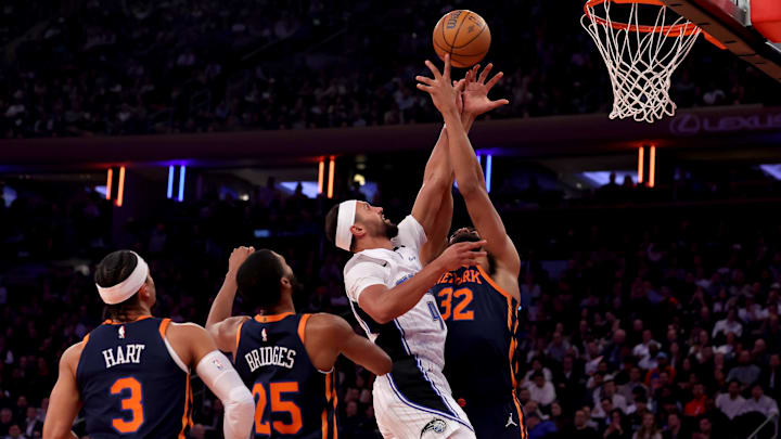 Orlando Magic guard Jalen Suggs (4) fights for a rebound against New York Knicks center Karl-Anthony Towns (32) and forward Mikal Bridges (25) and guard Josh Hart (3) during the first quarter at Madison Square Garden.