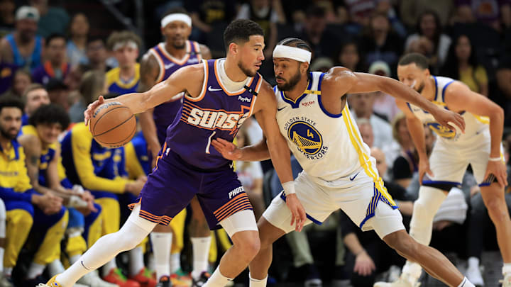 Apr 8, 2025; Phoenix, Arizona, USA; Phoenix Suns guard Devin Booker (1) dribbles the ball against Golden State Warriors guard Moses Moody (4) during the first half at Footprint Center. Mandatory Credit: Mark J. Rebilas-Imagn Images