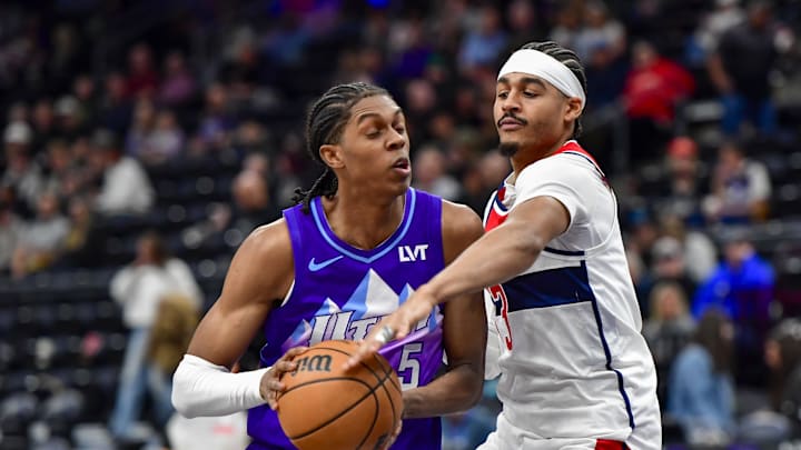 Mar 19, 2025; Salt Lake City, Utah, USA;  Washington Wizards guard Jordan Poole (13) makes steal attempt against Utah Jazz forward Cody Williams (5) during the second half at the Delta Center. Mandatory Credit: Peter Creveling-Imagn Images