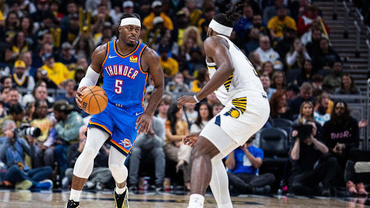 Oct 23, 2025; Indianapolis, Indiana, USA;  Oklahoma City Thunder guard Luguentz Dort (5) dribbles the ball while Indiana Pacers forward Jarace Walker (5) defends in the second half at Gainbridge Fieldhouse. Mandatory Credit: Trevor Ruszkowski-Imagn Images