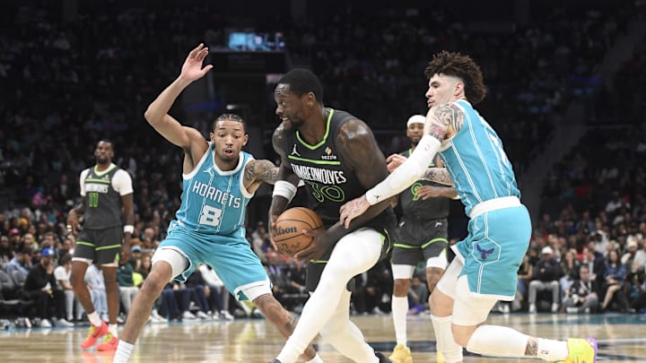 Mar 5, 2025; Charlotte, North Carolina, USA;  Minnesota Timberwolves forward Julius Randle (30) drives past Charlotte Hornets guard Nick Smith Jr. (8) and guard LaMelo Ball (1) during the second half at the Spectrum Center. Mandatory Credit: Sam Sharpe-Imagn Images