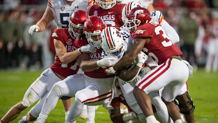 Nov 11, 2023; Fayetteville, Arkansas, USA;  Arkansas Razorbacks defensive back Hudson Clark (17) and defensive lineman Keivie Rose (93) and linebacker Jordan Crook (36) tackle Auburn Tigers running back Damari Alston (22) during the third quarter at Donald W. Reynolds Razorback Stadium. Auburn won 48-10. Mandatory Credit: Brett Rojo-Imagn Images