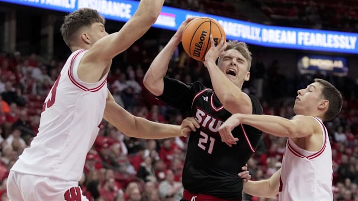 Southern Illinois-Edwardsville forward Myles Thompson (21) drives between Wisconsin forward Will Garlock (23) and guard Jack Janicki (5) during the first half of their game Monday, November 17, 2025 at the Kohl Center in Madison, Wisconsin.
