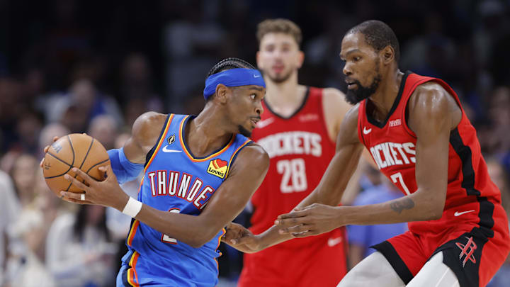 Oct 21, 2025; Oklahoma City, Oklahoma, USA; Oklahoma City Thunder guard Shai Gilgeous-Alexander (2) keeps the ball away from Houston Rockets forward Kevin Durant (7) during the second half at Paycom Center. Mandatory Credit: Alonzo Adams-Imagn Images