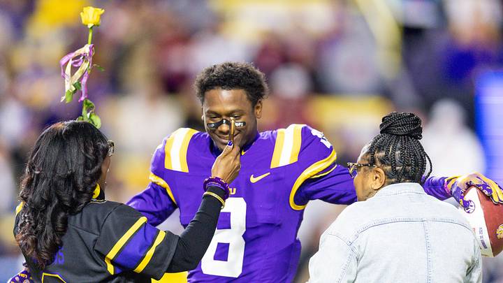 Nov 30, 2024; Baton Rouge, Louisiana, USA;  LSU Tigers safety Major Burns (8) hugs his family as seniors are being honored during the beginning of the first quarter at Tiger Stadium. Mandatory Credit: Stephen Lew-Imagn Images
