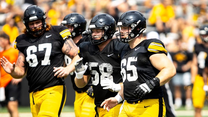 Aug 9, 2025; Iowa offensive linemen Gennings Dunker (67) Kade Pieper (58) and Logan Jones (65) run a drill during the Hawkeyes Kids Day NCAA football open practice at Kinnick Stadium in Iowa City, Iowa. Mandatory Credit: Joseph Cress for the Des Moines Register