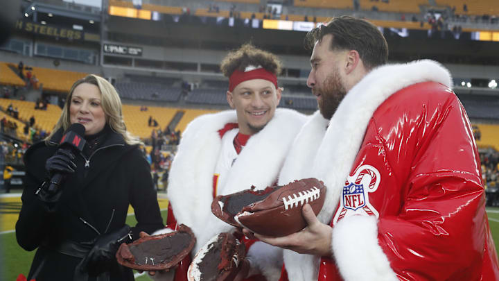 Dec 25, 2024; Pittsburgh, Pennsylvania, USA;  Kansas City Chiefs quarterback Patrick Mahomes (middle) and tight end Travis Kelce (right) open their Netflix Christmas GameDay cake after the Chiefs defeated the Pittsburgh Steelers at Acrisure Stadium. Mandatory Credit: Charles LeClaire-Imagn Images