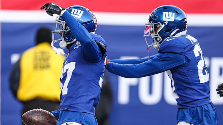 Dec 8, 2024; East Rutherford, New Jersey, USA; New York Giants cornerback Tre Hawkins III (37) celebrates his interception with safety Jason Pinnock (27) during the second half against the New Orleans Saints at MetLife Stadium.  