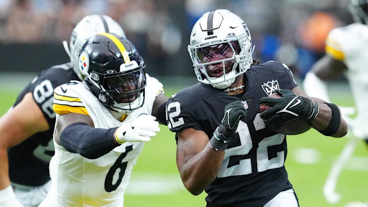 Oct 13, 2024; Paradise, Nevada, USA; Las Vegas Raiders running back Alexander Mattison (22) looks to evade the tackle attempt of Pittsburgh Steelers linebacker Patrick Queen (6) during the first quarter at Allegiant Stadium. Mandatory Credit: Stephen R. Sylvanie-Imagn Images