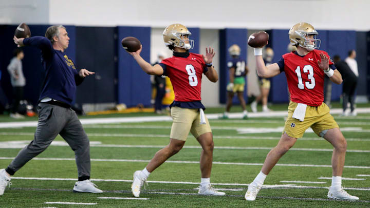 Notre Dame quarterbacks Kenny Minchey (8), center, and Riley Leonard (13) pass, as does quarterbacks coach Gino Guidugli at Notre Dame spring football practice Thursday, March 7, 2024, at the Irish Athletics Center in South Bend.