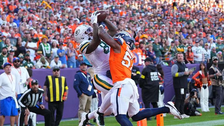 Dec 14, 2025; Denver, Colorado, USA; Green Bay Packers running back Josh Jacobs (8) catches a touchdown pass under pressure from Denver Broncos linebacker Dre Greenlaw (57) during the second quarter at Empower Field at Mile High. Mandatory Credit: Ron Chenoy-Imagn Images