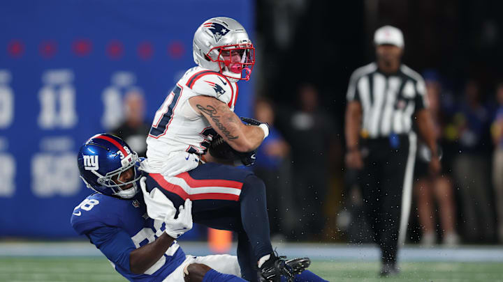 Aug 21, 2025; East Rutherford, New Jersey, USA; New England Patriots running back Shane Watts (30) is tackled by New York Giants cornerback Cor'Dale Flott (28) during the first half at MetLife Stadium. Mandatory Credit: Vincent Carchietta-Imagn Images