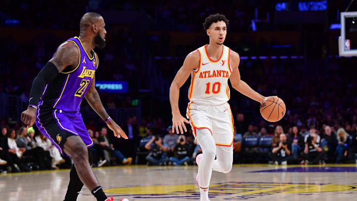 Jan 3, 2025; Los Angeles, California, USA;  Atlanta Hawks forward Zaccharie Risacher (10) moves the ball against Los Angeles Lakers forward LeBron James (23) during the first half at Crypto.com Arena. Mandatory Credit: Gary A. Vasquez-Imagn Images