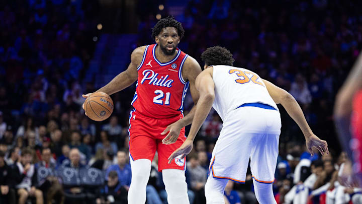 Nov 12, 2024; Philadelphia, Pennsylvania, USA; Philadelphia 76ers center Joel Embiid (21) dribbles the ball against New York Knicks center Karl-Anthony Towns (32) during the third quarter at Wells Fargo Center. Mandatory Credit: Bill Streicher-Imagn Images