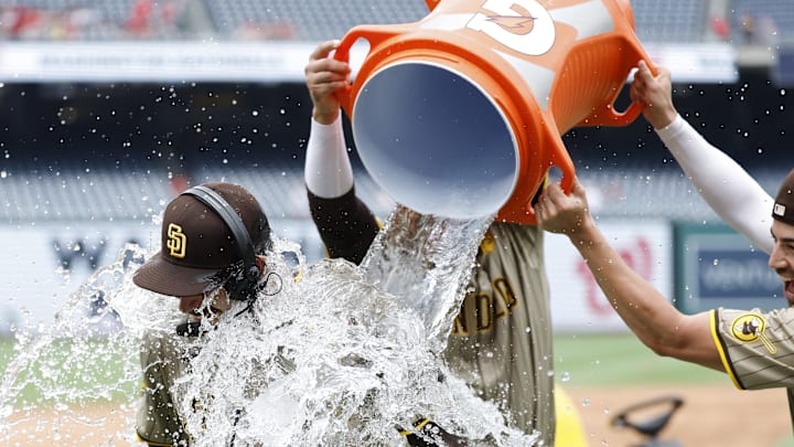 Jul 25, 2024; Washington, District of Columbia, USA; San Diego Padres pitcher Dylan Cease (84) is doused with a Gatorade cooler by Padres third baseman Manny Machado (13) and Padres third baseman Tyler Wade (14) while waiting for an on-air interview after throwing a no-hitter against the Washington Nationals at Nationals Park. Mandatory Credit: Geoff Burke-Imagn Images