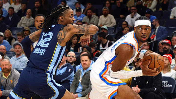 Mar 5, 2025; Memphis, Tennessee, USA; Oklahoma City Thunder guard Shai Gilgeous-Alexander (2) handles the ball as Memphis Grizzlies guard Ja Morant (12) defends during the first quarter at FedExForum. Mandatory Credit: Petre Thomas-Imagn Images