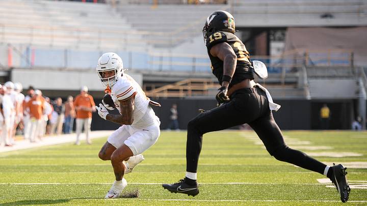 Oct 26, 2024; Nashville, Tennessee, USA;  Vanderbilt Commodores safety Jalen Gilbert (18) drags Texas Longhorns wide receiver DeAndre Moore Jr. (0) down just before the goal line during the first half at FirstBank Stadium. Mandatory Credit: Steve Roberts-Imagn Images