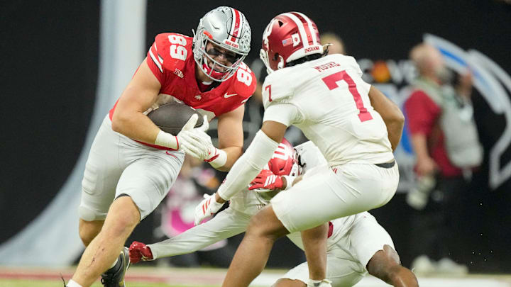 Ohio State Buckeyes tight end Will Kacmarek (89) rushes the ball along the sideline as Indiana Hoosiers defensive back Louis Moore (7) moves in Saturday, Dec. 6, 2025, during the Big Ten football championship at Lucas Oil Stadium in Indianapolis.