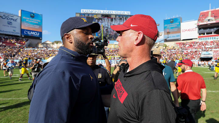 Dec 31, 2024; Tampa, FL, USA;  Michigan Wolverines head coach Sherrone Moore greets Alabama Crimson Tide head coach Kalen Deboer after the ReliaQuest Bowl at Raymond James Stadium. Mandatory Credit: Nathan Ray Seebeck-Imagn Images