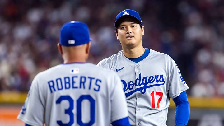 Sep 23, 2025; Phoenix, Arizona, USA; Los Angeles Dodgers pitcher/designated hitter Shohei Ohtani looks at manager Dave Roberts as he walks to the pitchers mound against the Arizona Diamondbacks at Chase Field. Mandatory Credit: Mark J. Rebilas-Imagn Images