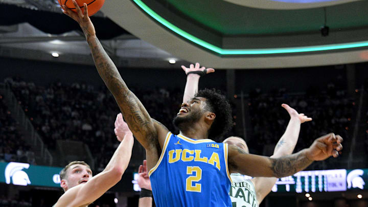 Feb 17, 2026; East Lansing, Michigan, USA; UCLA Bruins guard Donovan Dent (2) drives past the Michigan State Spartans defense during the first half at Jack Breslin Student Events Center. Mandatory Credit: Dale Young-Imagn Images