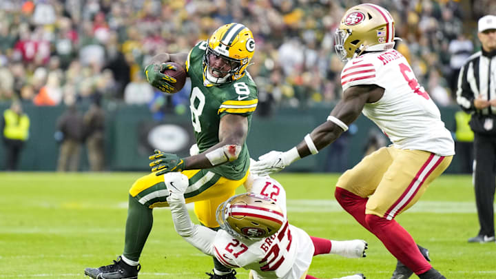 Nov 24, 2024; Green Bay, Wisconsin, USA;  Green Bay Packers running back Josh Jacobs (8) is tackled by San Francisco 49ers safety Ji'Ayir Brown (27) during the first quarter at Lambeau Field. Mandatory Credit: Jeff Hanisch-Imagn Images