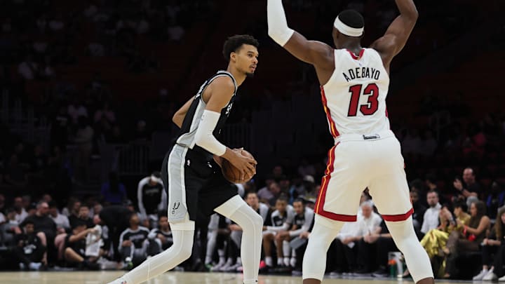 San Antonio Spurs center Victor Wembanyama (1) protects the basketball from Miami Heat center Bam Adebayo (13) during the first quarter at Kaseya Center. Mandatory Credit: Sam Navarro-Imagn Images