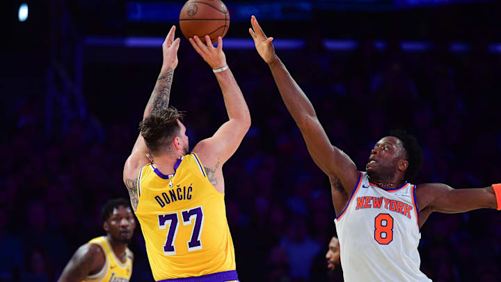 Mar 6, 2025; Los Angeles, California, USA; Los Angeles Lakers guard Luka Doncic (77) shoots against New York Knicks forward OG Anunoby (8) during the first half at Crypto.com Arena. Mandatory Credit: Gary A. Vasquez-Imagn Images