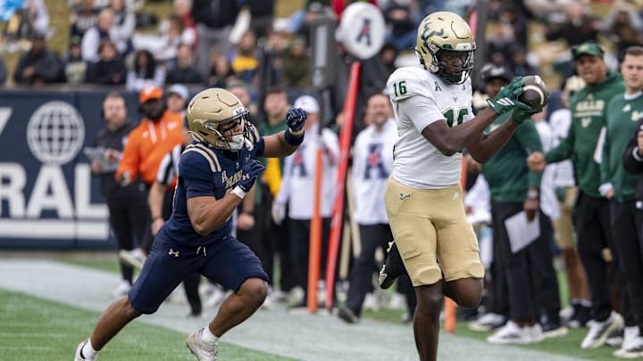 Nov 15, 2025; Annapolis, Maryland, USA;  South Florida Bulls wide receiver Jeremiah Koger (16) catches a pass along the sidelines as Navy Midshipmen cornerback Justin Ross (17) defends during the second half at Navy-Marine Corps Memorial Stadium. Navy Midshipmen defeated South Florida Bulls 41-28. Mandatory Credit: Tommy Gilligan-Imagn Images