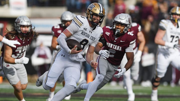 Montana State Bobcats quarterback Justin Lamson (8) carries the ball against Montana Grizzlies safety Micah Harper (2)