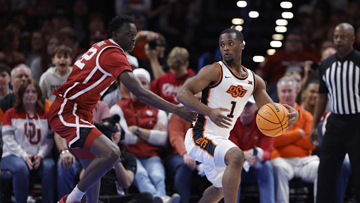 Dec 13, 2025; Oklahoma City, Oklahoma, USA; Oklahoma State Cowboys guard Kanye Clary (1) moves the ball around Oklahoma Sooners forward Kuol Atak (22) during the first half at Paycom Center. Mandatory Credit: Alonzo Adams-Imagn Images Dec 13, 2025; Oklahoma City, Oklahoma, USA; Oklahoma State Cowboys guard Kanye Clary (1) moves the ball around Oklahoma Sooners forward Kuol Atak (22) during the first half at Paycom Center. Mandatory Credit: Alonzo Adams-Imagn Images