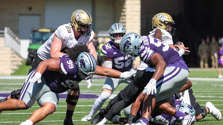 Sep 27, 2025; Manhattan, Kansas, USA; UCF Knights quarterback Tayven Jackson (2) tries to get away from Kansas State Wildcats defensive tackles Malcolm Alcorn-Crowder (55) and Uso Seumalo (99) during the third quarter at Bill Snyder Family Football Stadium. Mandatory Credit: Scott Sewell-Imagn Images
